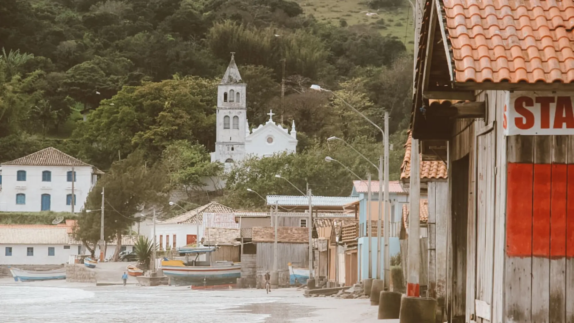 Rua do centro histórico de Garopaba, com a igreja matriz ao fundo e as casas antigas