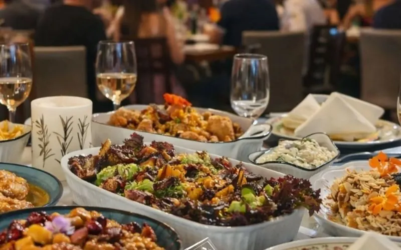 Mesa posta com saladas, arroz e pratos típicos